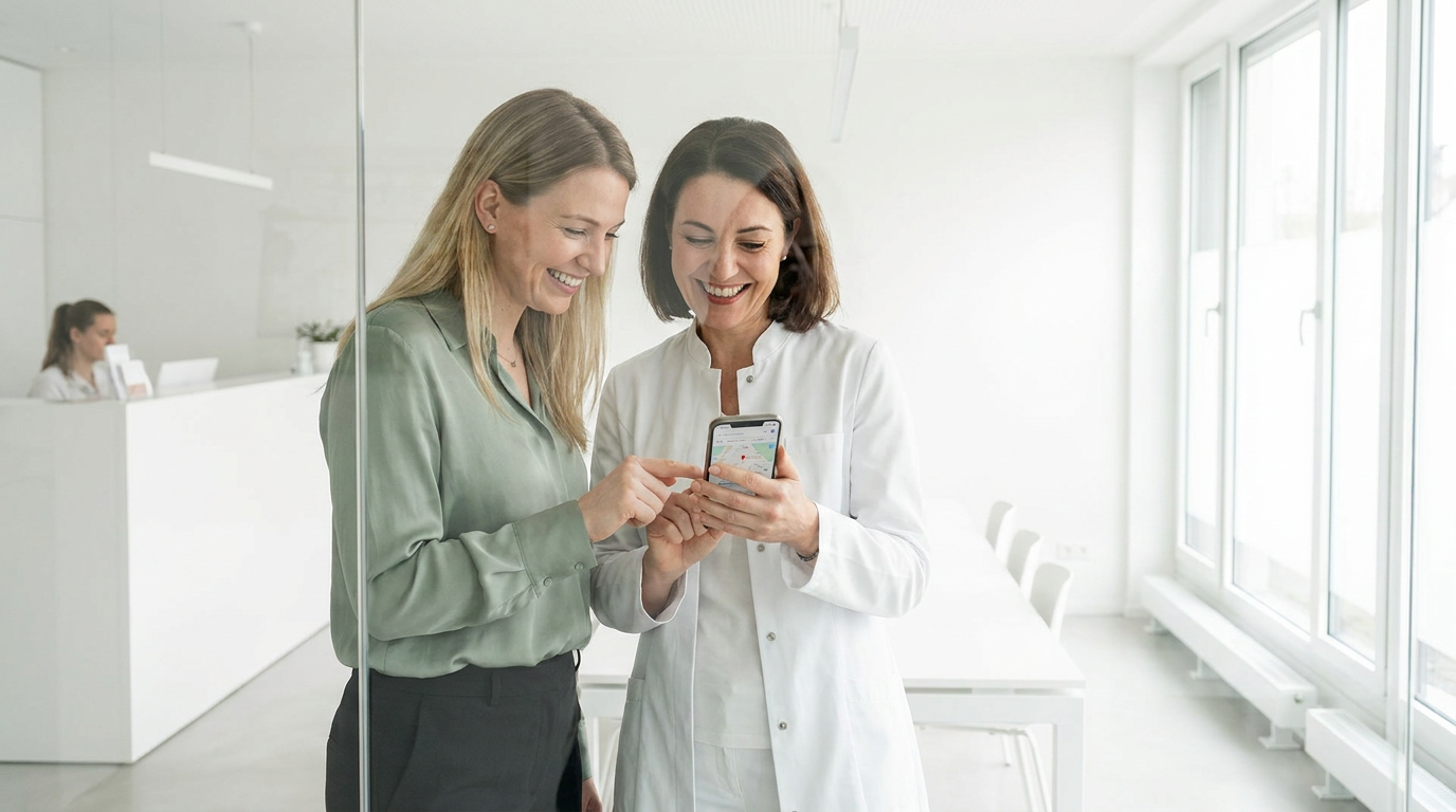 Ärztin und Patientin schauen auf ein Smartphone mit digitalem Stadtplan für Local SEO Praxis